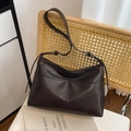 Borsa tote in pelle testa di moro con cuciture fini e tracolla sottile su una sedia - Marrone