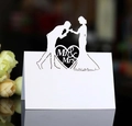 Laser cut white paper wedding place card featuring Mr & Mrs silhouettes and heart detail - White