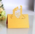 Detail of laser-cut gold wedding place card with Mr & Mrs silhouette and heart design - Gold