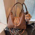 Vintage brown leather tote bag with metal flower detail and plush dog charm accessory - Brown with Pendant