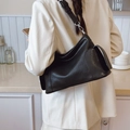 Borsa tote nera minimalista con tasca laterale e tracolla regolabile indossata da modella - Nero