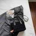 Elegant black suede bucket bag with quilted pattern and gold hardware on grey suit - Black without Pendant