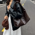 Large dark brown shoulder bag in glossy oil wax leather worn with a stylish street outfit - Brown