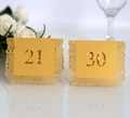 Macro detail of laser-cut gold lace wedding table cards with hollow numbers 21 and 30 - Numbers 21-30 / Gold