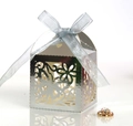 Close-up of laser-cut silver wedding favor box with butterfly pattern and blue ribbon - Reflective Silver