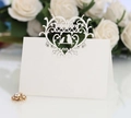 Elegant white laser-cut place card featuring romantic heart and bird motifs for weddings - Ivory