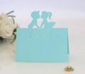 Macro detail of laser-cut light blue wedding place card featuring a boy and girl silhouette - Tiffany Blue