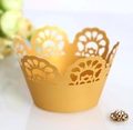 Close-up of golden laser-cut lace cupcake wrappers with elegant crown pattern - Gold