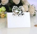 Macro detail of laser-cut wedding place card with lovebird heart design on pearlescent paper - Ivory