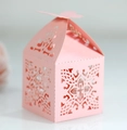 Makro-Detail einer lasergeschnittenen rosa Geschenkbox mit Spitzenmuster und Kreuz - Rosa