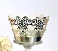 Close-up of laser-cut silver cupcake wrappers with elegant European filigree patterns - Reflective Silver