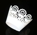 Close-up of white laser-cut lace cupcake wrappers with elegant floral hollow patterns - White