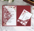 Detail of laser-cut burgundy wedding invitation set with floral inner card on marble surface - Dark Red