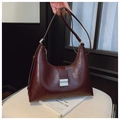 Close-up of dark brown glossy leather hobo bag with a silver metallic rectangular buckle - Raspberry Red