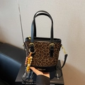 Leopard print bucket handbag with black trim and gold hardware details - Black with Pendant