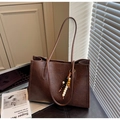 Brown leather tote bag featuring retro texture and beaded charm in a minimalist office setting - With Charm / Coffee