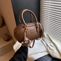 Vintage brown Boston bag with ATN embossing and fuzzy charm in soft lighting - With Charm / Brown
