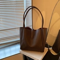 Minimalist large dark brown leather tote bag with long straps on artistic books - Brown