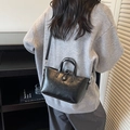 Glossy black leather bucket tote bag with adjustable shoulder strap and metal buckle - Black