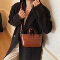 Dark brown leather bucket bag with top handles and adjustable strap for women - Brown