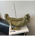 Detailed view of olive green crescent bag on a book showing nylon texture and strap - Green
