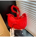 Detail of red crescent hobo bag featuring pleated handle and decorative ribbon bow - Red
