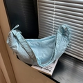 Minimalist light blue crescent bag with nylon fabric and wide strap on books - Blue