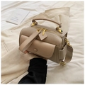 Detail of beige pebble leather handbag featuring a wide shoulder strap and gold hardware - Khaki