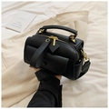 Macro shot of black lychee texture leather bag with gold zipper and metal hardware - Black