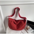 Detalle de bolso de media luna en nylon rojo oscuro con correa ajustable y accesorios - Rojo