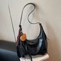 Black glossy hobo bag with teddy bear charm and striped ribbon in a variant view - Black with Pendant