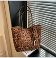 Détail du sac cabas léopard avec anses en cuir et pendentif ethnique en perles de bois - Imprimé léopard