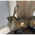 Dettaglio della borsa tote in nylon oliva con coulisse e ciondolo di peluche a toast - Verde Militare Con Pendente