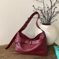 Borsa tote vintage in pelle bordeaux con fibbia argento su superficie in legno - Rosso