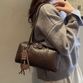 Deep coffee brown faux leather boston bag with chocolate charm on female model - Coffee with Pendant