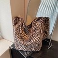 Borsa tote con motivo zebrato marrone e bianco e logo in metallo su bancone nero - Marrone