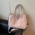 Minimalistische nylon draagtas in oudroze met verstelbare schouderband op leren bank - Roze