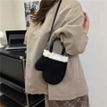 Bolso bandolera negro con forma de manopla y ribete de pelo, mostrado sobre una modelo - Negro