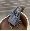 Detailaufnahme der graublauen Eimer-Handtasche aus Kieselleder mit Silberkette und Nieten - Blau