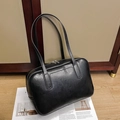 Close-up of minimalist black faux leather tote bag with silver double zipper and texture - Black