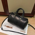 Detail van vintage zwarte boston tas met matgouden hardware en zachte lederen textuur - Zwart
