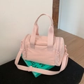 Detail of light pink nylon gym bag with dual handles and adjustable shoulder strap on props - Light Pink