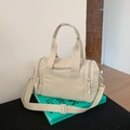 Detail view of large cream nylon travel bag with wide handles and adjustable shoulder strap - Off-white