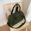 Detailansicht der olivgrünen Zylindertasche aus Nylon mit verstellbarem Schultergurt und Griff - Grün