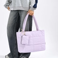 Borsa tote trapuntata viola chiaro con pochette abbinata indossata da una modella - Viola
