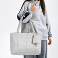 Detail of light grey quilted tote bag with matching mini purse on white background - Gray