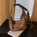 Dettaglio di borsa hobo marrone in denim lavato con fibbia dorata e ciondolo a treccia - con portachiavi / Marrone
