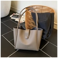 Dettaglio borsa tote in pelle taupe con chiusura magnetica e marchio HOCOMO impresso - Grigio elefante