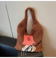 Macro detail of brown knit plush tote bag featuring an embroidered pink bucket hat patch - Brown