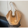 Détail d'un grand sac cabas en daim camel avec serrure en métal sur des livres anglais - Kaki